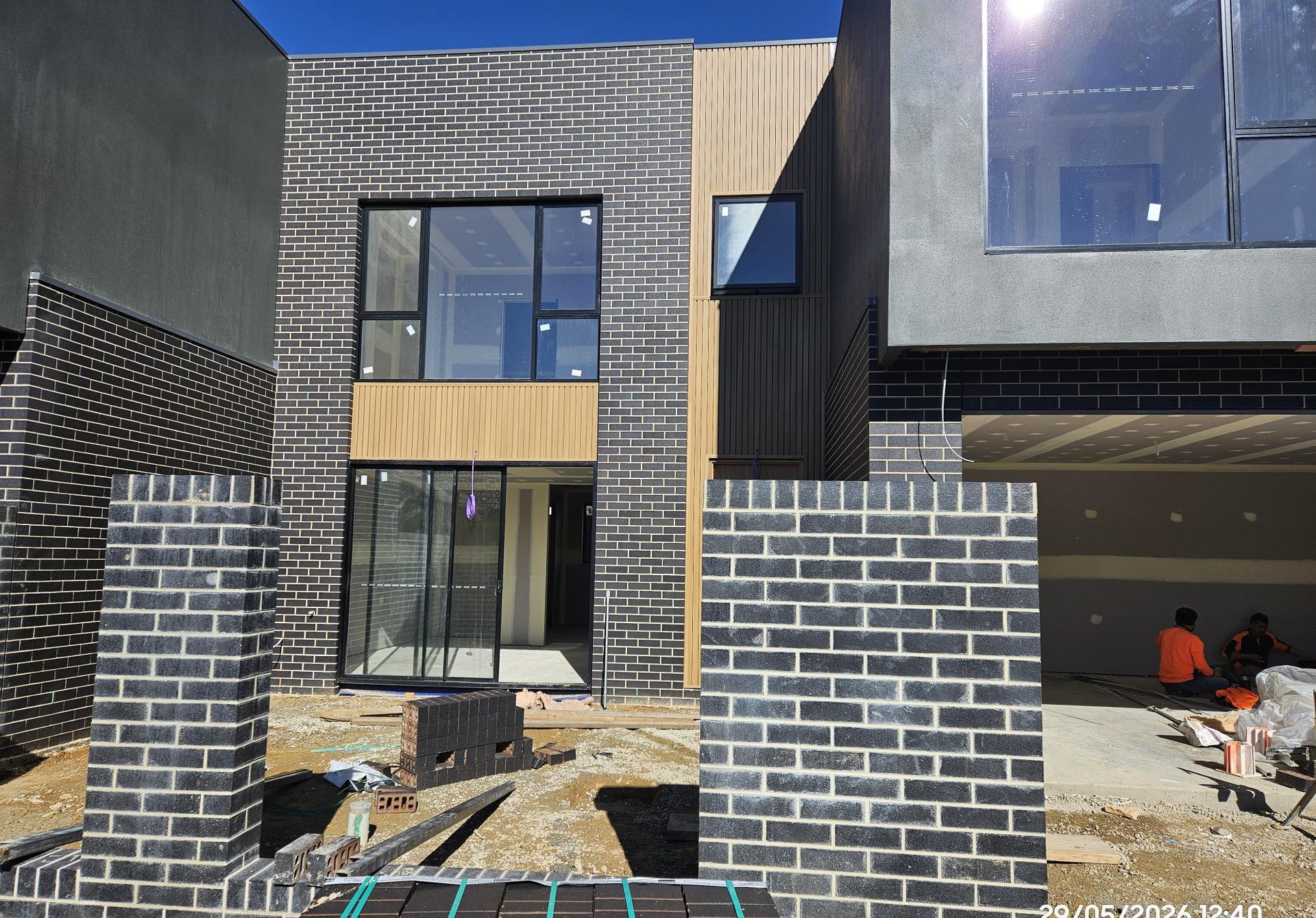 Private rear courtyard framed by charcoal brick and timber-look cladding